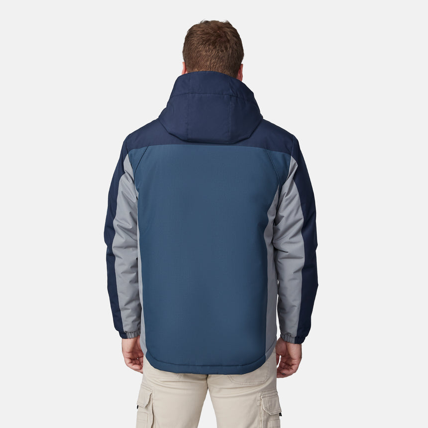 [Joe is 6'0" wearing size M.] Men’s Free Country hooded zip-front jacket in blue with gray paneling—featuring dual vertical zippered chest pockets and side hand pockets. Paired with light khaki pants for a clean, functional look suited to cold-weather layering and outdoor versatility.