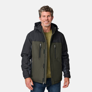 [Kolby is 6'2" wearing size M.]  "Men’s Free Country two-tone zip-front jacket with black upper section and olive green lower panels—features dual vertical zippered chest pockets, side hand pockets, and attached hood. Layered over a green crewneck tee and blue jeans for versatile, outdoor-ready style.