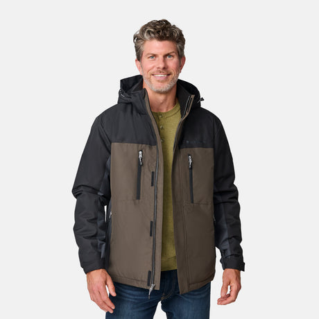 [Kolby is 6'2" wearing size M.]  "Men’s Free Country two-tone zip-front jacket with black upper section and olive green lower panels—features dual vertical zippered chest pockets, side hand pockets, and attached hood. Layered over a green crewneck tee and blue jeans for versatile, outdoor-ready style.