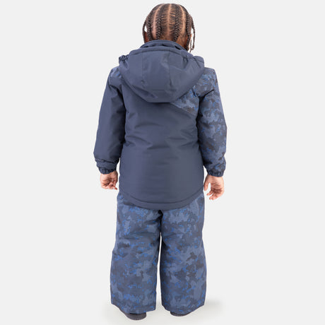 A child with braided hair wears the Free Country Boys' Toddler Boarder Jacket and Bib Pant Set, featuring a navy blue water-resistant winter jacket and matching patterned snow pants made from recycled polyester, against a plain white background.