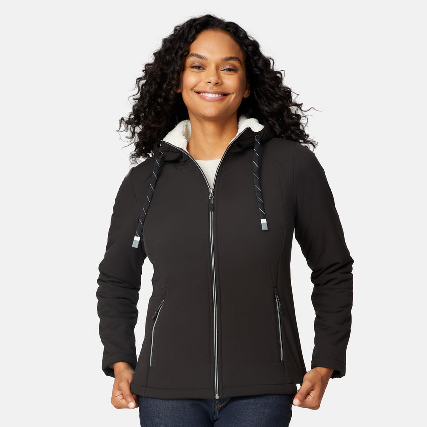 [Angelique is 5'10" wearing size S.] Women’s Free Country black hooded jacket with zip-up closure, white sherpa lining visible at the collar, and metallic drawstring tips. Features zippered side pockets and is styled with blue jeans for a clean, versatile winter look.