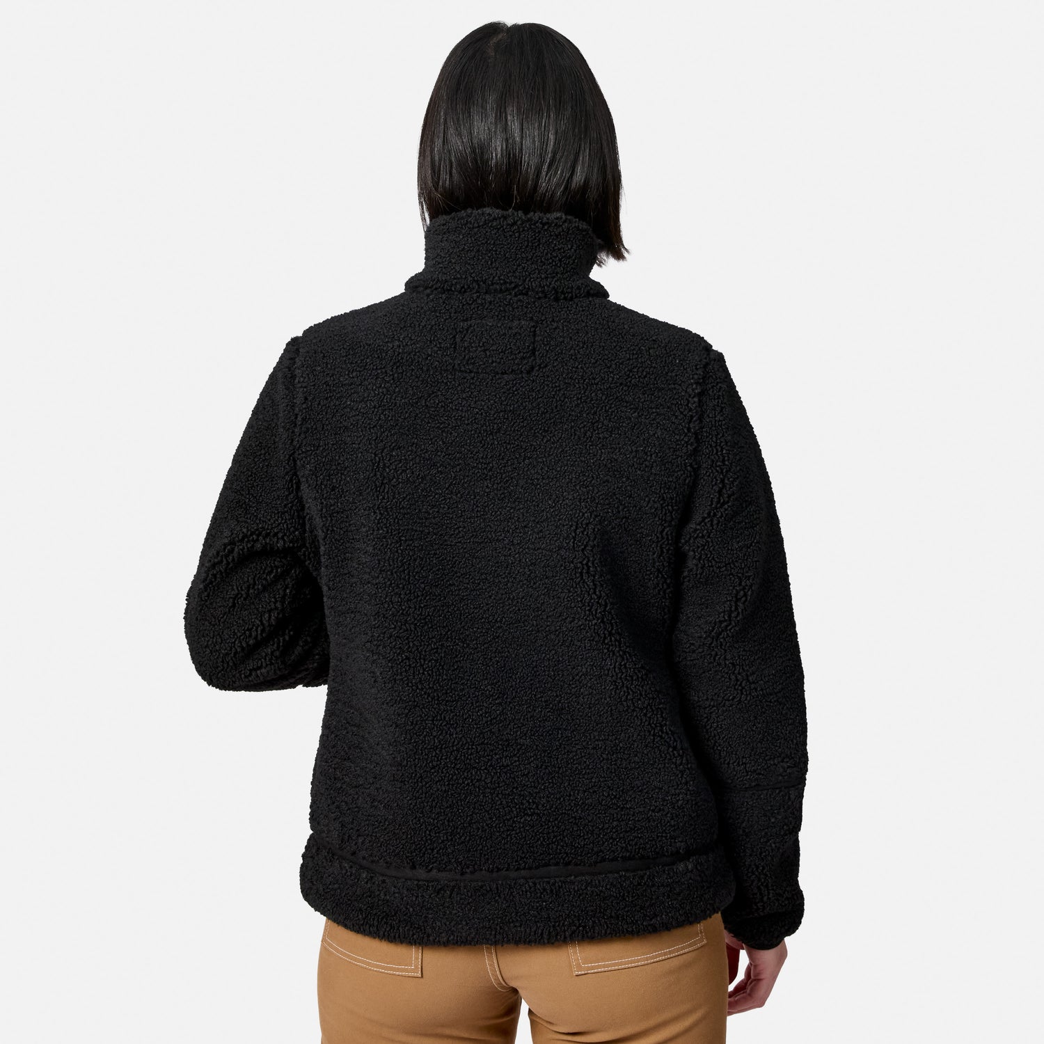 Back view of woman in black faux shearling jacket detailing fleece texture and hem