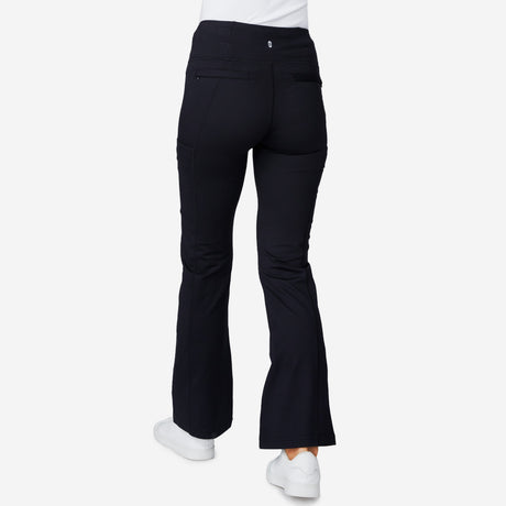 A person is shown from the back wearing Free Country Women's Trail 2 Town Flare Pants and white sneakers, standing against a plain white background.
