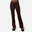 A person models Free Country Women’s Trail 2 Town Flare Pants in Espresso, featuring visible seams and side pockets, paired with olive green and black sneakers against a plain white backdrop—ideal for any outing.
