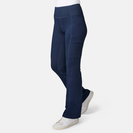 Person wearing Free Country Women’s Trail 2 Town Flare Pants in Midnight with white sneakers, standing against a plain white background.