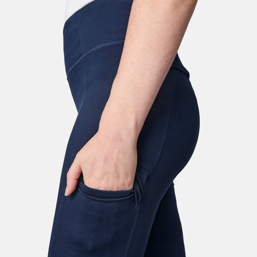 A woman in Free Country Women’s Trail 2 Town Flare Pants (UPF 50+) places her left hand in a side pocket. The close-up shows waist to mid-thigh against a plain light background.