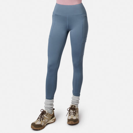 Free Country Women’s Trail 2 Town Legging in blue, four-way stretch, high-waisted with side pockets, worn with gray socks and tan hiking shoes.
