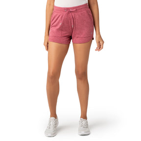 A person stands against a plain white background, shown from the waist down, wearing Clearance Women's Free 2 Go Out Short in pink petal hem, a white top, and white sneakers.