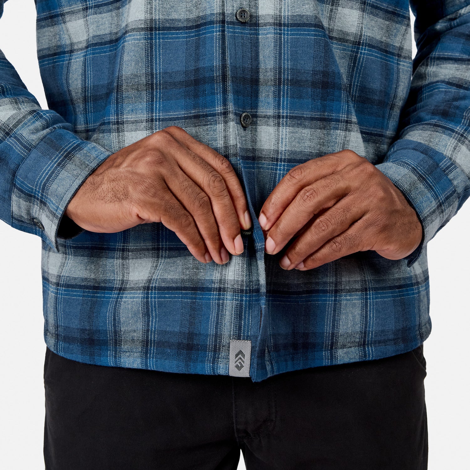 [Model is wearing size M.] Men's Easywear II fleece lined plaid flannel shirt worn by a man with hands clasped at his waist
