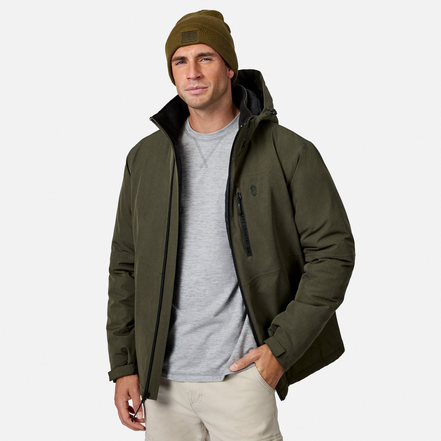 [Model is wearing size M.] A man wearing an olive green hooded jacket over a gray t-shirt and khaki pants, paired with an olive green beanie, photographed against a light gray studio background.