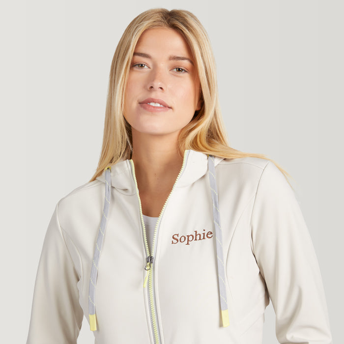 Woman wearing a white hoodie with 'Sophie' embroidered on it against a light gray background