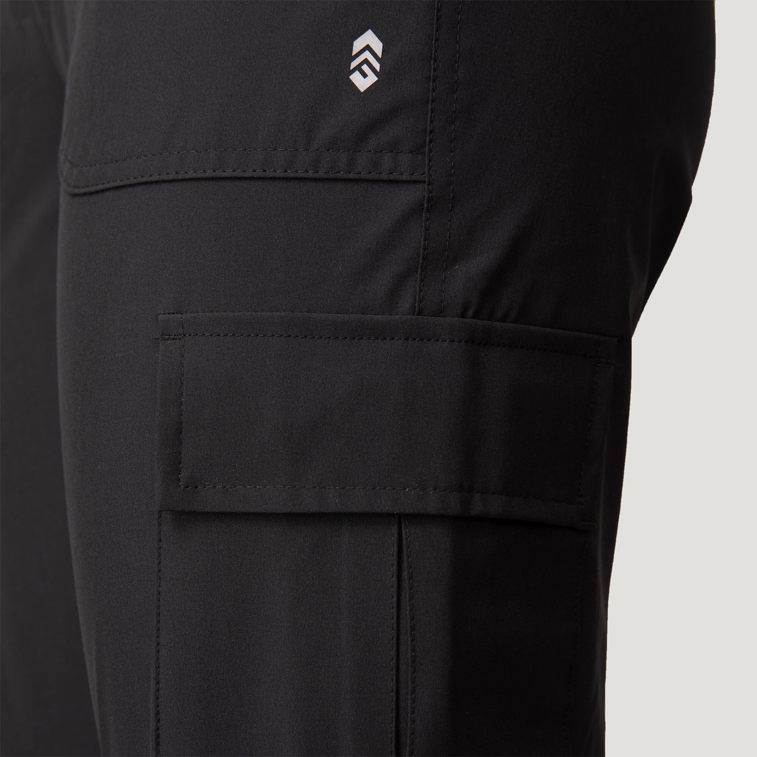 Close-up of Free Country Women’s Get Out There Fleece Lined Jogger highlighting a large cargo pocket, small white logo above it, and fabric texture with visible stitching. These fleece-lined joggers offer water resistance, durability, and versatility.