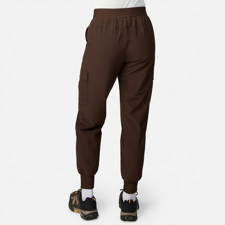 A person wears brown Free Country Women’s Get Out There Fleece Lined Jogger pants with elastic waistband and cuffs, black outdoor shoes, and white socks, shown from the back against a plain light background—ideal for fans of Get Out There Pants.