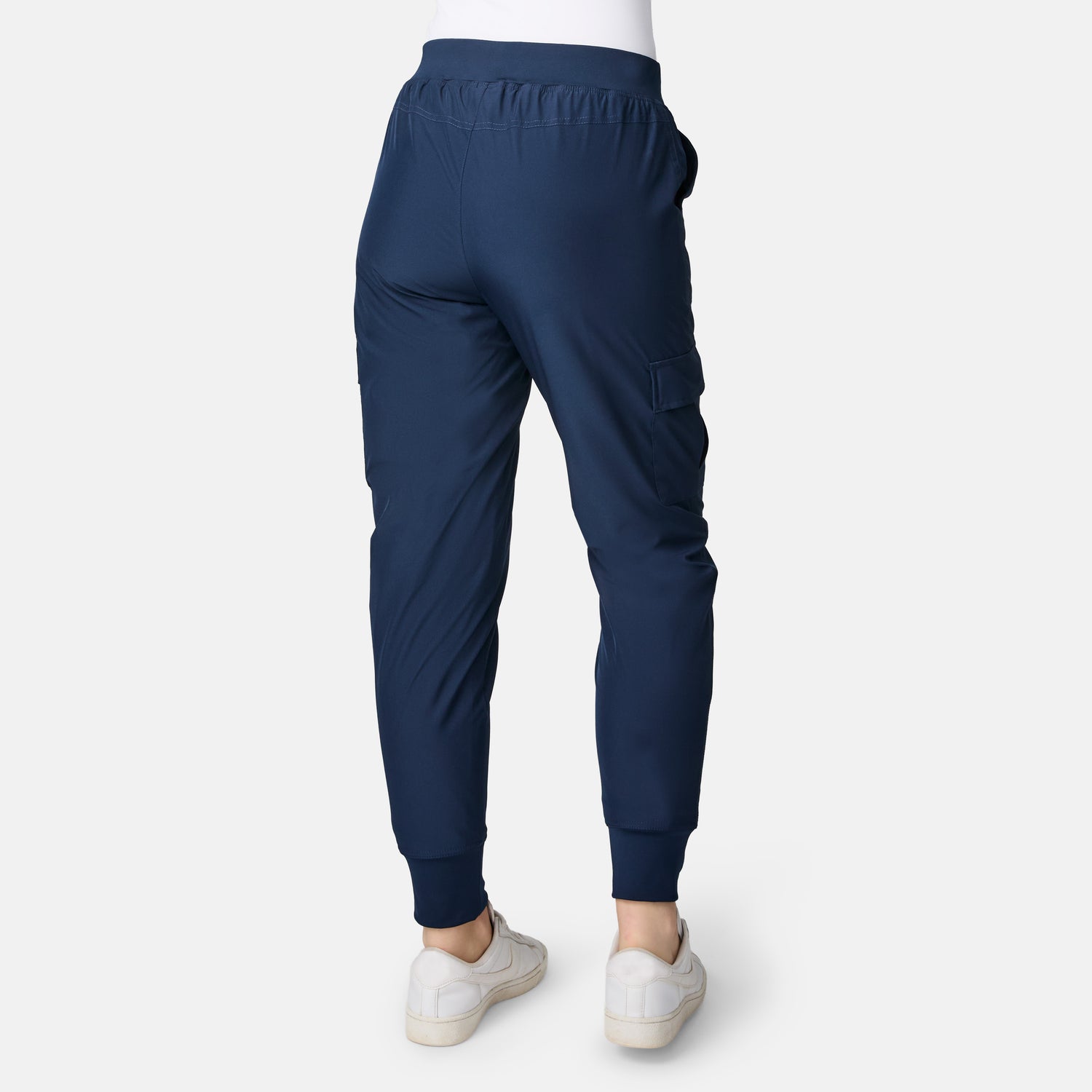 Model in navy Free Country Women’s Get Out There Fleece Lined Jogger and white sneakers, shown from the back on a plain white background. These joggers have an elastic waistband, pockets, fitted ankle cuffs, and offer everyday comfort.