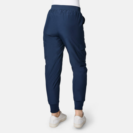 Model in navy Free Country Women’s Get Out There Fleece Lined Jogger and white sneakers, shown from the back on a plain white background. These joggers have an elastic waistband, pockets, fitted ankle cuffs, and offer everyday comfort.