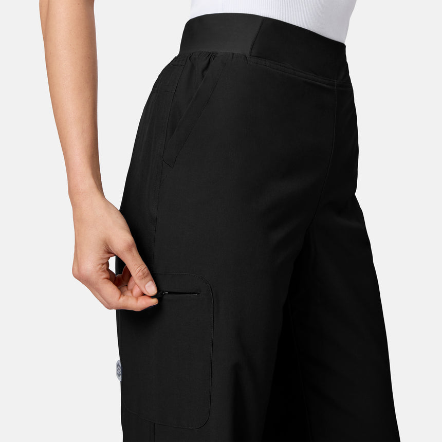 [Model is wearing size S.] Close-up of a person wearing black wide-leg cargo pants, showing the side pocket and hand adjusting the zipper, against a light gray studio background.