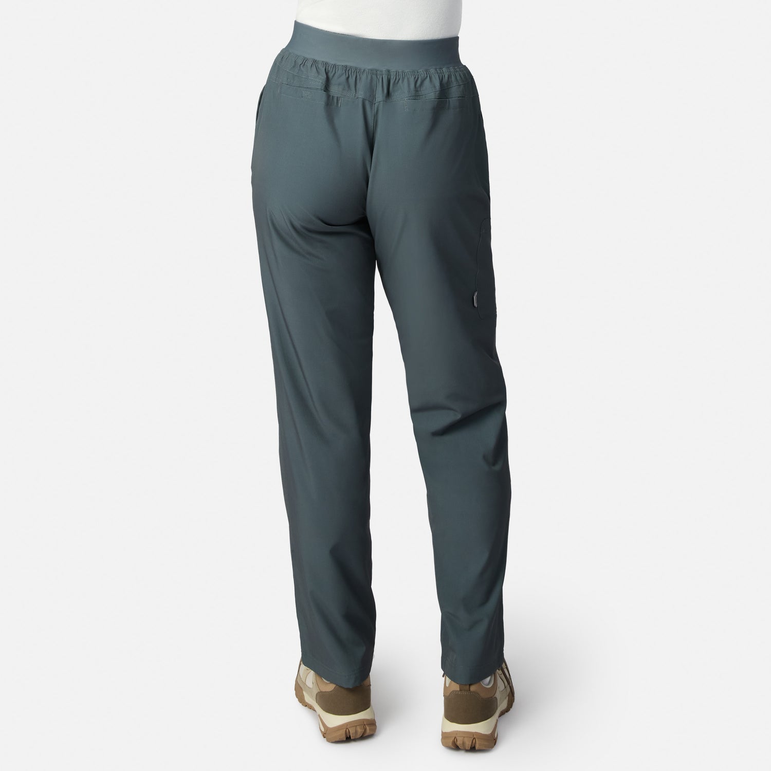 Woman wearing Free Country Women’s Get Out There Fleece Lined Pants in teal with light brown shoes, shown from the back against a plain white background.