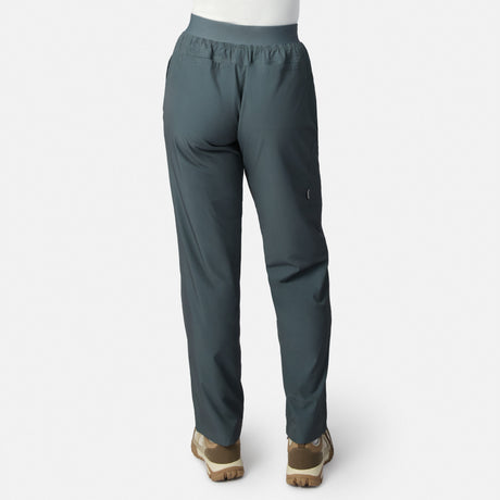 Woman wearing Free Country Women’s Get Out There Fleece Lined Pants in teal with light brown shoes, shown from the back against a plain white background.