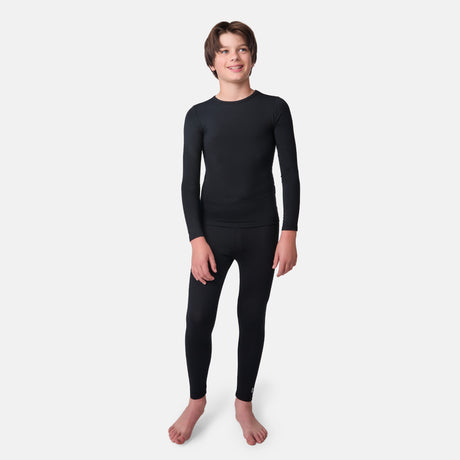 Child wearing a black long-sleeve base layer shirt and black base layer pants on a white background