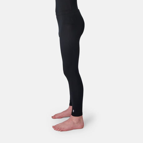 Child wearing a black long-sleeve base layer shirt and black base layer pants on a white background