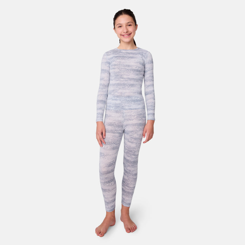 Child wearing a gray and white striped long-sleeve base layer top and leggings on a light gray background