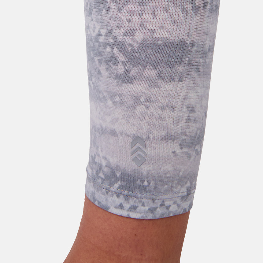 Close-up of a person wearing a patterned capri legging on a white background