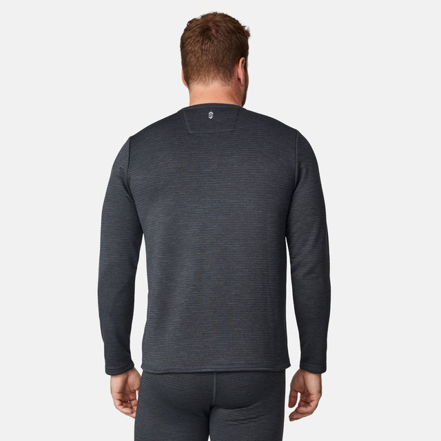 A man, shown from the back against a plain light background, is wearing the Free Country Men's Force Grid Fleece Base Layer Top in long-sleeve dark gray, paired with matching pants.