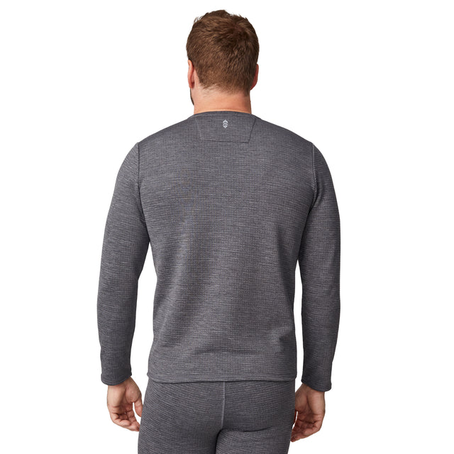 A man is standing with his back to the camera against a white background, wearing the Free Country Men's Force Grid Fleece Base Layer Top and matching pants in gray.