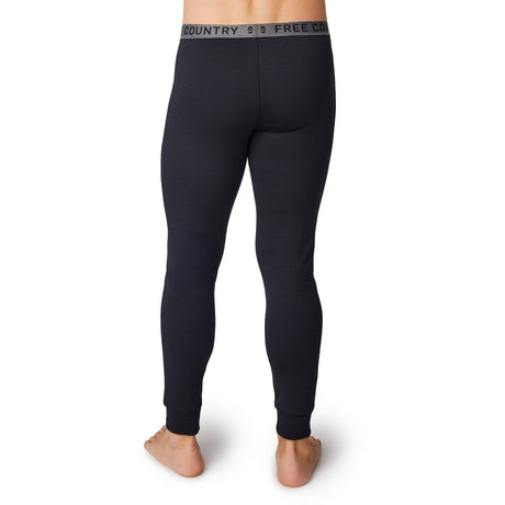 A barefoot man is shown from the back wearing Free Country Men's Force Grid Fleece Base Layer Bottoms—black thermal leggings with a grey waistband reading FREE COUNTRY.
