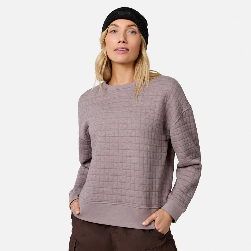 Woman in a Free Country Women’s UltraFill Fleece Crew Neck Pullover Top in Mocha, dark pants, and black knit beanie stands with hands in pockets against a plain white background.