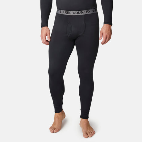 A person stands barefoot against a plain white background, wearing black Men’s Microtech® Heat Cocarber® Coffee Base Layer Bottoms from Free Country. Crafted with moisture-wicking fabric, these leggings feature a waistband emblazoned with the Free Country logo.