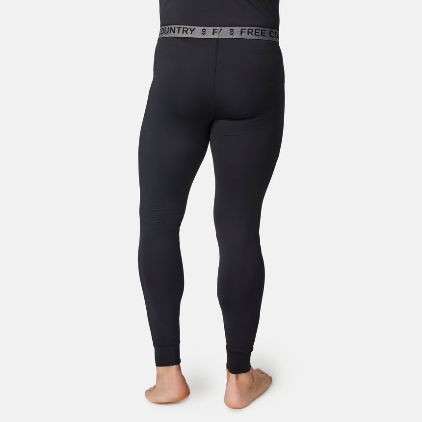 A man stands barefoot, facing away, wearing black fitted Men’s Microtech® Heat Cocarber® Coffee Base Layer Bottoms by Free Country, with the brand name displayed on the waistband. Made from recycled materials, these base layers offer moisture-wicking and anti-odor protection. The background is plain white.