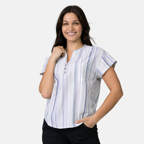 A woman with long dark hair models the Free Country Women's Easy Breezy Shirt, standing against a plain light background with one hand on her hip and the other touching her collar.