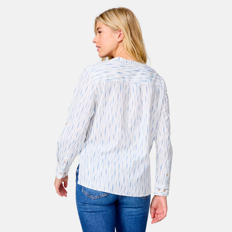 A woman in blue jeans and the Clearance Women's Easy Breezy Long Sleeve Shirt, a relaxed cotton-linen blend with adjustable roll-up sleeves, stands facing away and looks over her left shoulder against a plain light background.