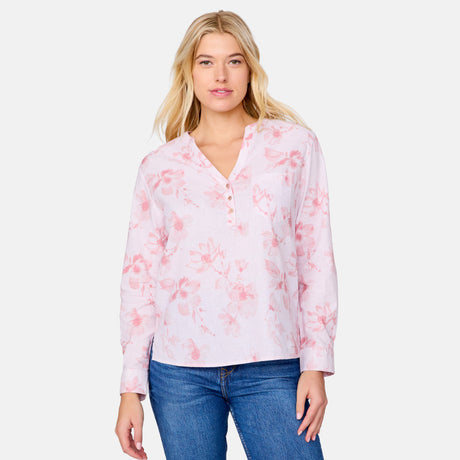 A woman with long blonde hair wears the Clearance Women's Easy Breezy Long Sleeve Shirt, a light pink floral cotton-linen blend top with adjustable roll-up sleeves, paired with blue jeans against a plain light background.