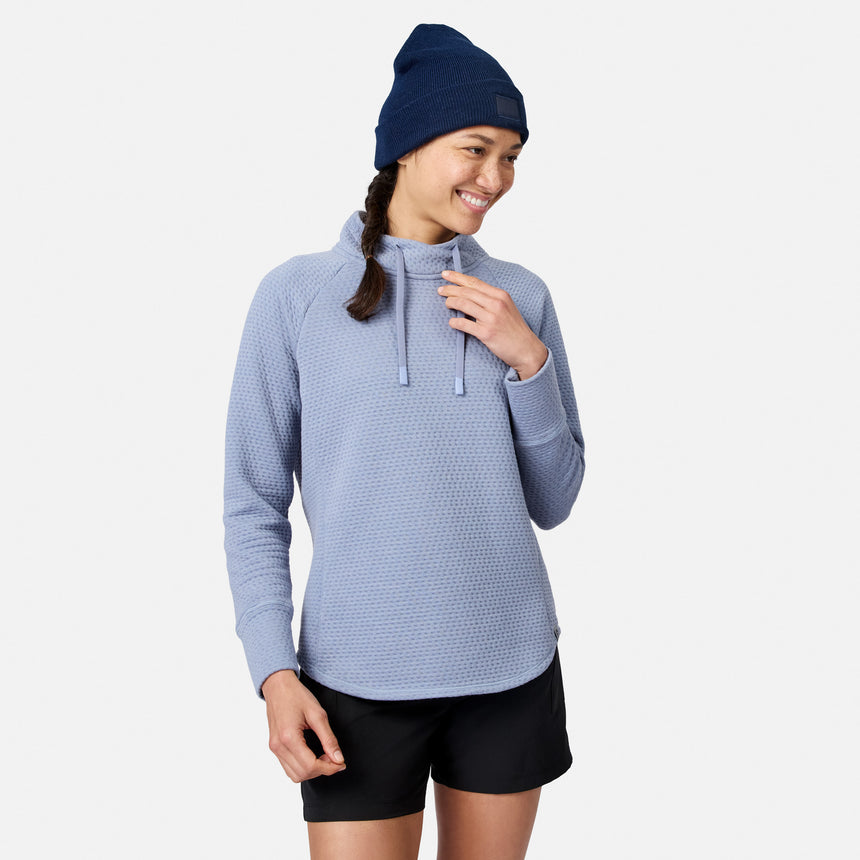 A woman wearing a Dusk Women’s UltraFill Cowl Neck Top with seamless quilting and a navy blue beanie.