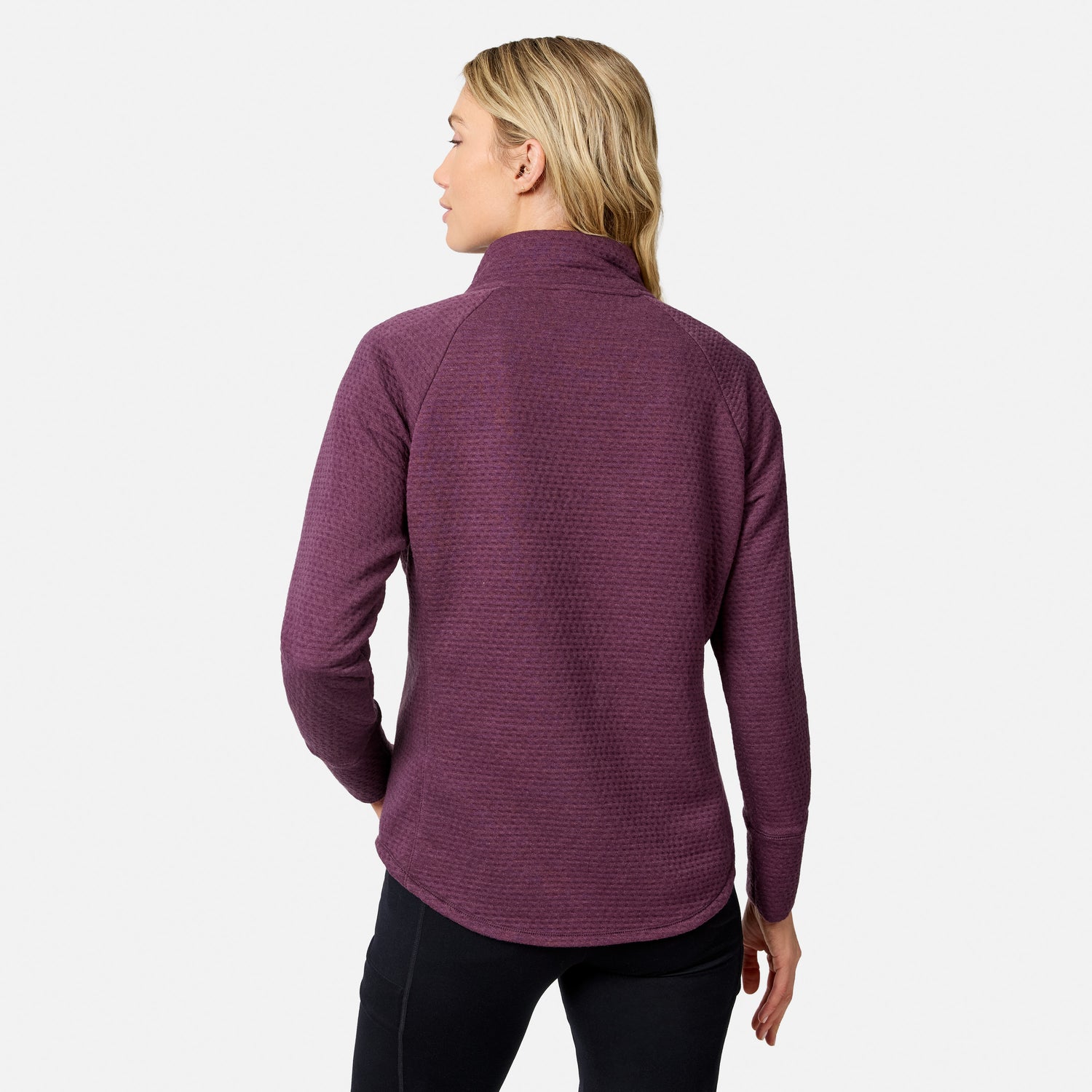 Back view of a person wearing a purple long-sleeved Free Country Women’s UltraFill Cowl Neck Top with a high neckline and black leggings.