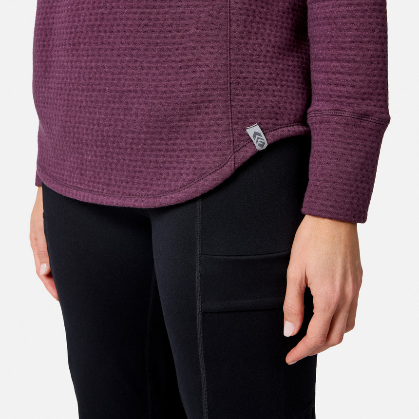 Close-up of a person wearing a purple long-sleeved Free Country Women’s UltraFill Cowl Neck Top and black leggings with side pockets.