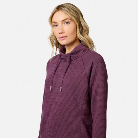 Woman wearing a purple, seamless Women’s UltraFill Cowl Neck Top with long sleeves and a drawstring.