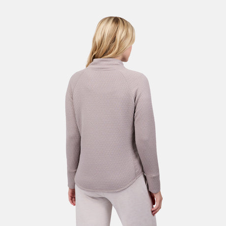 A woman with blonde hair is shown from the back in a light gray Free Country Women's UltraFill Cowl Neck Top and matching seamless quilted pants against a plain white background.