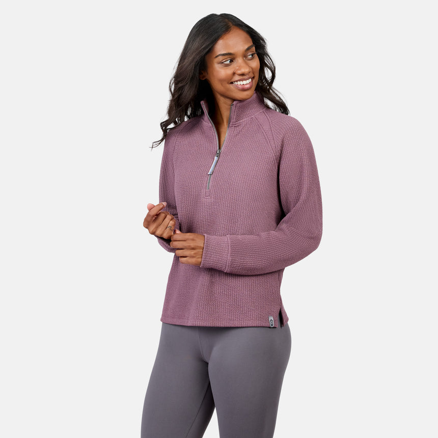 Woman wears the Free Country Women’s Ripple Knit Half Zip Top, light purple, paired with gray leggings and smiles against a plain white background—showcasing effortless casual style.