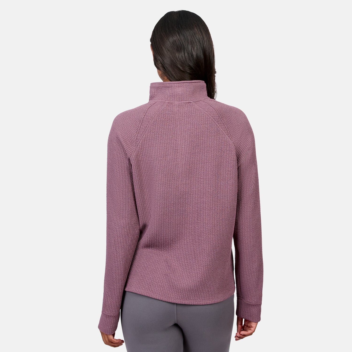 A person faces away, wearing the Free Country Women’s Ripple Knit Half Zip Top in mauve with gray pants against a plain white background—ideal for casual layering.