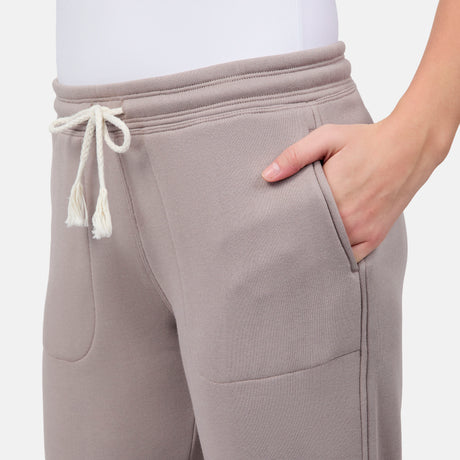 [Model is wearing size S] Light taupe sweatpants with a white drawstring on a light gray background