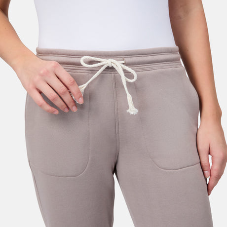 [Model is wearing size S] Light taupe sweatpants with a white drawstring on a plain background