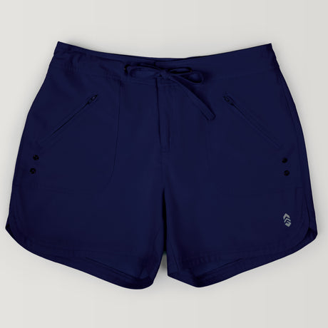 The Free Country Women's 5" Bermuda Board Short in navy features a drawstring waistband, two zippered front pockets, a small logo at the left hem, and is made from quick-drying fabric. Shorts are shown laid flat on a light background.