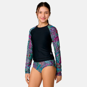 [Model is wearing a size Medium.] Girl wearing the Free Country Girls' Fresco Rash Guard and Bikini Swim Set in Black Fresco, size M, featuring a raglan sleeve rash guard and racerback tankini top and lined bikini bottom made from recycled polyester fabric that provides four way stretch and upf protection #color_ Black-Fresco