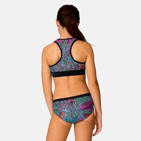 [Model is wearing a size Medium.] Girl wearing the Free Country Girls' Fresco Rash Guard and Bikini Swim Set in Black Fresco, size M, featuring a raglan sleeve rash guard and racerback tankini top and lined bikini bottom made from recycled polyester fabric that provides four way stretch and upf protection #color_ Black-Fresco