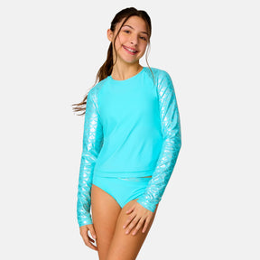 [Model is wearing a size Medium.] Girl wearing the Free Country Girls' Foil Mermaid Rash Guard and Bikini Swim Set in Aquatopia Foil Mermaid, size M, featuring a raglan sleeve rash guard and racerback tankini top and lined bikini bottom made from recycled polyester fabric that provides four way stretch and upf protection #color_ Aquatopia-Foil Mermaid