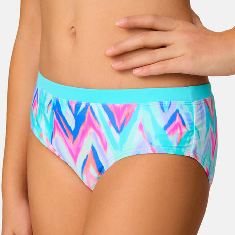 [Model is wearing a size Medium.] Girl wearing the Free Country Girls' Fresco Rash Guard and Bikini Swim Set in Aquatopia Oasis Chevron, size M, featuring a raglan sleeve rash guard and racerback tankini top and lined bikini bottom made from recycled polyester fabric that provides four way stretch and upf protection #color_ Aquatopia-Oasis-Chevron
