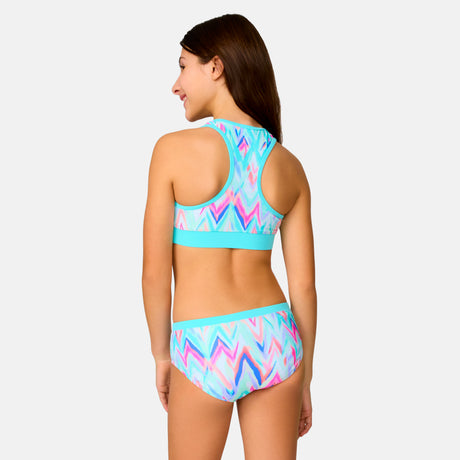 [Model is wearing a size Medium.] Girl wearing the Free Country Girls' Fresco Rash Guard and Bikini Swim Set in Aquatopia Oasis Chevron, size M, featuring a raglan sleeve rash guard and racerback tankini top and lined bikini bottom made from recycled polyester fabric that provides four way stretch and upf protection #color_ Aquatopia-Oasis-Chevron